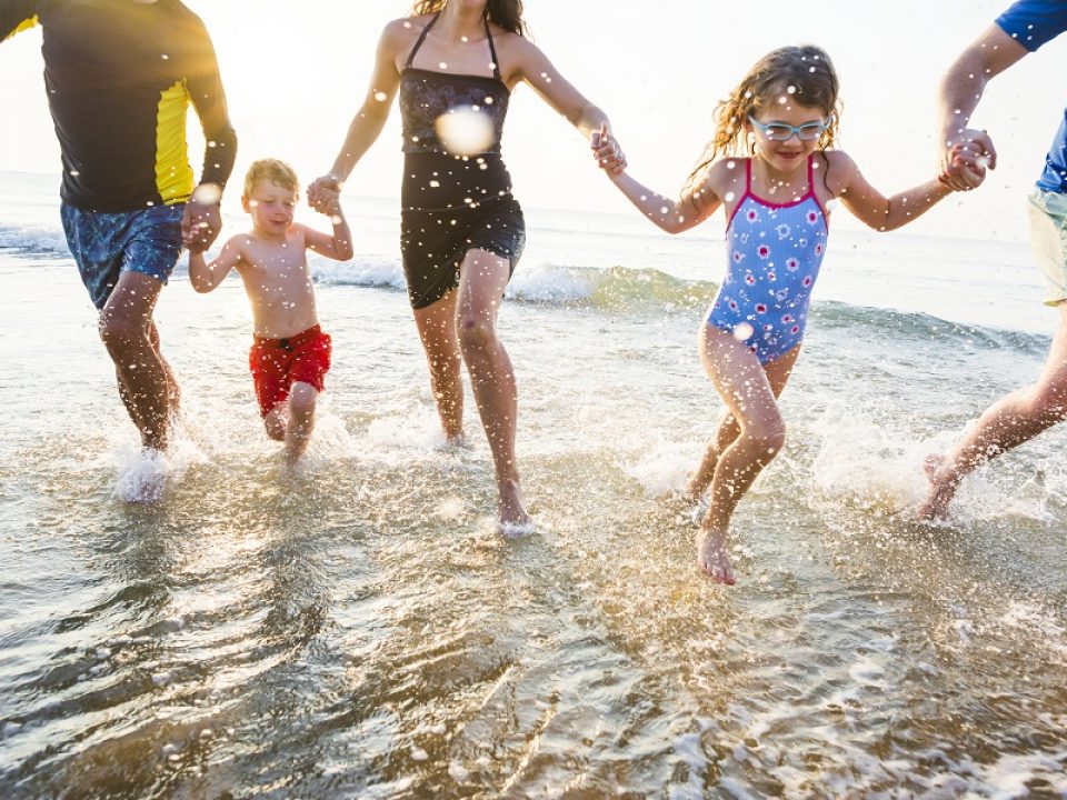 family running in water at beach