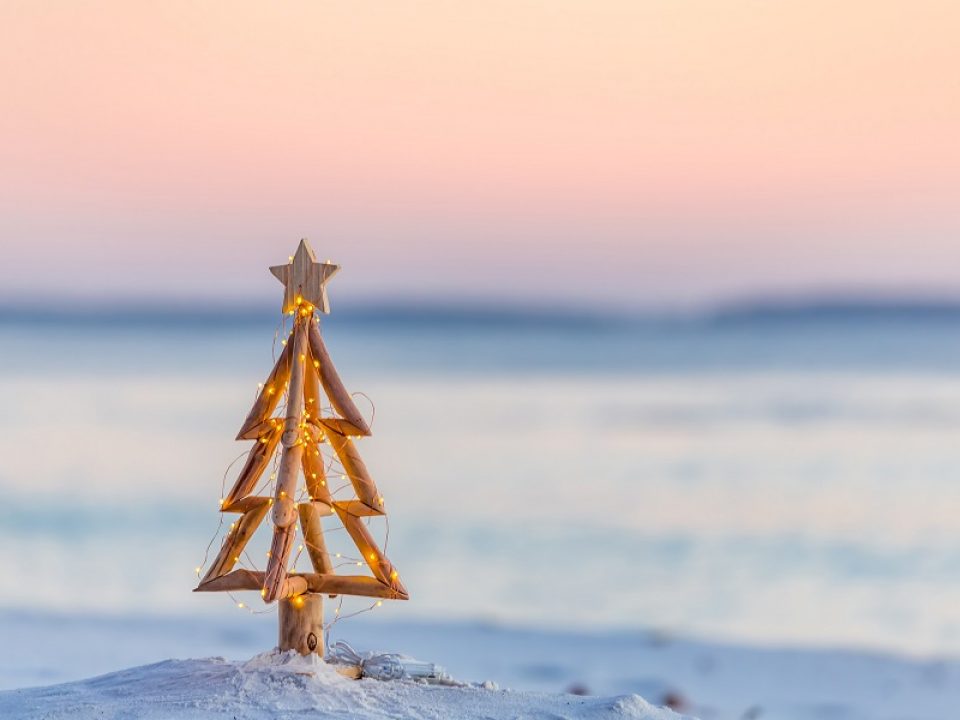small wooden christmas tree in sand