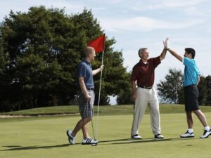 3 men on golf course celebrating